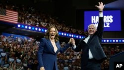 FILE - Democratic presidential nominee Vice President Kamala Harris accompanied, left, by her running mate Minnesota Gov. Tim Walz, appear at a campaign event in Philadelphia, Aug. 6, 2024.