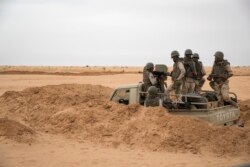FILE - Soldiers of the Mauritania army wait in an armed vehicle at a G5 Sahel task force outpost in the southeast of Mauritania, along the border with Mali, Nov. 22, 2018.