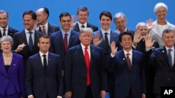 President Donald Trump, front center, stands with other world leaders as they pose for a group picture at the start of the G-20 Leader's Summit inside the Costa Salguero Center in Buenos Aires, Argentina, Nov. 30, 2018. 