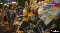 A woman places a flower at the Erawan shrine, the site of Monday's deadly blast, in central Bangkok, Thailand, Aug. 20, 2015.