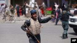 在8月7号的一起爆炸事件后，一名阿富汗警察守卫现场