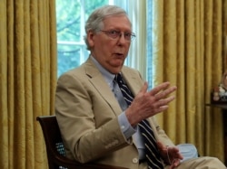 FILE - Senate Majority Leader Mitch McConnell meets with President Donald Trump in the Oval Office, July 20, 2020.