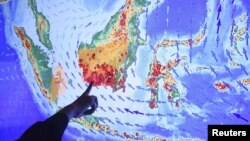 Seorang petugas menunjukkan titik-titik api kebakaran hutan dan lahan di Pulau Kalimantan pada sebuah layar di kantor Kementerian Lingkungan Hidup dan Kehutanan, di Jakarta, Selasa 22/9 (foto: Reuters/Antara).