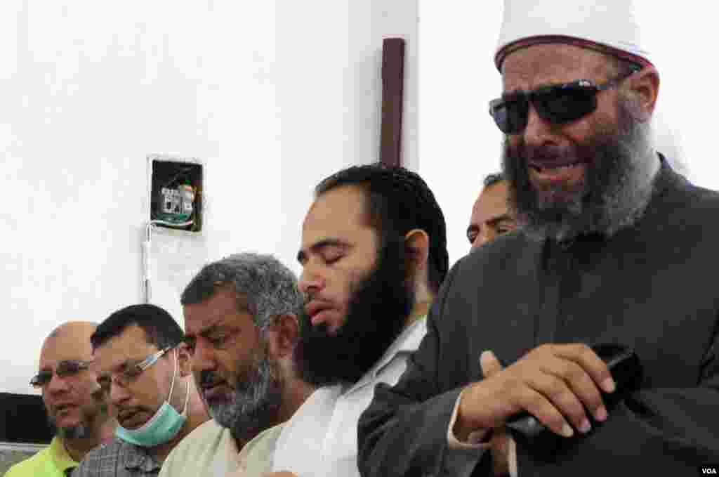 A sheikh leads mourners in prayers at a makeshift morgue at Rabia el-Adawiya mosque in Cairo, July 27, 2013, (Elizabeth Arrott/VOA). 