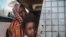 FILE - In this file picture taken Tuesday, April 14, 2015, a Sudanese girl looks out of the window while waiting with her mother in a public bus in Izba, an impoverished neighborhood on the outskirts of Khartoum, Sudan. Forty percent of children…