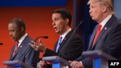 FILE - Candidates Donald Trump (R), Ben Carson (L) and Scott Walker (C) are seen participating in the first Republican presidential debate in Cleveland, Ohio, Aug. 6, 2015.