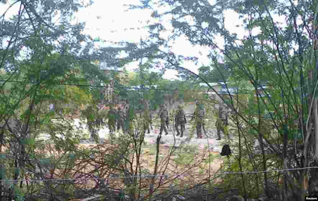 In this mobile phone image, soldiers from the Kenya Defense Force move behind a thicket in the town of Garissa, April 2, 2015.