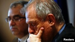 Cyprus Central Bank Governor Panicos Demetriades (L) and Cypriot Finance Minister Michael Sarris listen to reporters' questions during a news conference at the Central Bank of Cyprus in Nicosia, Mar. 26, 2013.