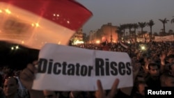 Para demonstran anti Presiden Morsi melakukan unjuk rasa di Lapangan Tahrir, Kairo sambil membawa spanduk yang menyamakan Morsi sebagai diktator (27/11). 