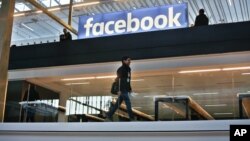 FILE - The Facebook logo is displayed at a start-up companies gathering at Paris' Station F, in Paris, France, Jan. 17, 2017. Leaked documents reveal how the company determines what content to allow.