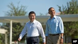 President Barack Obama and Chinese President Xi Jinping, left, walk at the Annenberg Retreat of the Sunnylands estate, June 8, 2013, in Rancho Mirage, Calif.