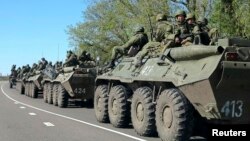 Russian servicemen drive armoured personnel carriers on the outskirts of the city of Belgorod near the Russian-Ukrainian border, April 25, 2014.
