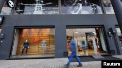 FILE - A man walks past a Nike shop on Venice Street in Benghazi, Libya, Nov. 7, 2013.