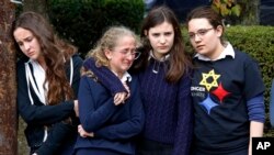 Students from the Yeshiva School in the Squirrel Hill neighborhood of Pittsburgh pay their respects as the funeral procession for Dr. Jerry Rabinowitz passes their school en route to Homewood Cemetery following a funeral service at the Jewish Community Center, Oct. 30, 2018.
