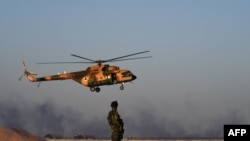 FILE - An Afghan Commando stands guard while an Afghan Air Force helicopter flies past during a combat training exercise in the Afghan province of Helmand, Aug. 27, 2017. An Afghan air force pilot was gunned down Dec. 30, 2020, in Kandahar.