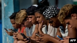 FILE - Young peeple use a hotspot to connect to the internet, in Havana, Cuba, June 06, 2019. Cuba this month passed a cyber law critics say aims to limit political and civic freedoms in the Caribbean island nation.