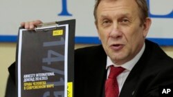 Sergei Nikitin, direktur Amnesty International untuk Rusia, menunjukkan laporan mengenai situasi HAM di Moskow (24/2). (AP/Ivan Sekretarev)