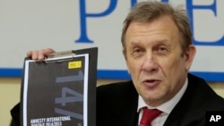 2015年2月24日国际特赦组织俄罗斯代表处主任谢尔盖•尼基京在新闻发布会上出示国际特赦年度报告俄语副本