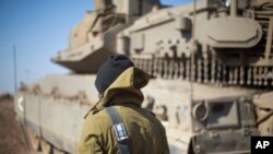 Seorang tentara Israel berdiri di dekat sebuah tank di dekat perbatasan dengan Suriah di Dataran Tinggi Golan yang dikuasai Israel, Senin, 28 November 2016. (Foto: dok).