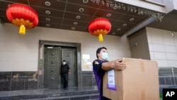 A FedEx employee removes a box from the Chinese Consulate in Houston, July 23, 2020.