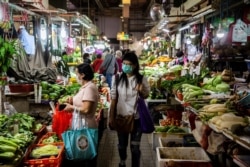 A customer walks through a wet market wearing a protective face mask in Hong Kong on Feb. 25, 2020.