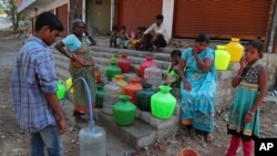 Residents of a poor neighborhood collect potable water from a public tap in Hyderabad, India, March 18, 2020.