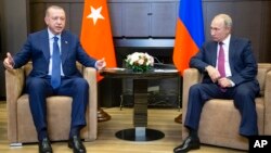FILE - Turkish President Recep Tayyip Erdogan (L) speaks to Russian President Vladimir Putin, during their meeting in the Bocharov Ruchei residence in the Black Sea resort of Sochi in Sochi, Russia, Sept. 17, 2018.