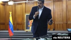 Presiden Venezuela Nicolas Maduro menunjukkan peralatan militer dalam pertemuan dengan angkatan bersenjata dengan Angkatan Bersenjata Bolivia di Istana Miraflores di Caracas, Venezuela, 4 Mei 2020.