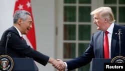 Singapore's Prime Minister Lee Hsien Loong and U.S. President Donald Trump shake hands before giving joint statements in the Rose Garden of the White House in Washington, Oct. 23, 2017.