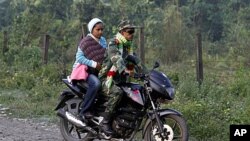 A former Maoist rebel rides a motorbike and arrives with his family for an integration program at Shaktikhor Cantonment in Chitwan, about 220 kilometers (140 miles) southwest of Katmandu, Nepal, November 19, 2011.