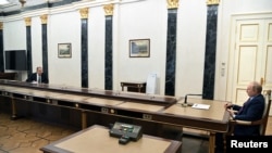 블라디미르 푸틴(오른쪽) 러시아 대통령이 14일 모스크바에서 세르게이 라브로프 외무장관의 보고를 받고 있다.  