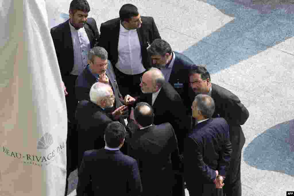 Iran&#39;s Foreign Minister Mohammad Javad Zarif (C on left) and head of the Atomic Energy Organization of Iran Ali Akbar Salehi (C on right) talk outside with aides after a morning negotiation session with U.S. Secretary of State John Kerry over Iran&#39;s nucler program in Lausanne, Switzerland.