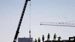 FILE - Construction workers unload supplies off a hoisted pallet on a rooftop in Atlanta, June 7, 2016. Workers' productivity increased in the third quarter at a 3.1 percent rate, the Labor Department reported Dec. 6, 2016.