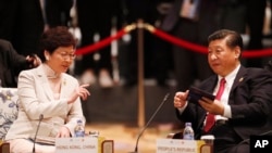 Le président chinois Xi Jinping, à droite, et le chef de l'exécutif de Hong Kong Carrie Lam s'entretiennent lors du dialogue APEC-ASEAN, en marge du sommet de l'APEC, à Danang, au Vietnam, le 10 novembre 2017. 