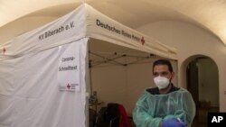 Radnik Crvenog krsta ispred šatora za testiranje na kovid u Nemačkoj (Stefan Puchner/dpa, AP)