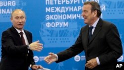 FILE - Russian President Vladimir Putin, left, and Germany's former Chancellor Gerhard Schroeder attend an economic forum in St.Petersburg, Russia, June 21, 2012. 