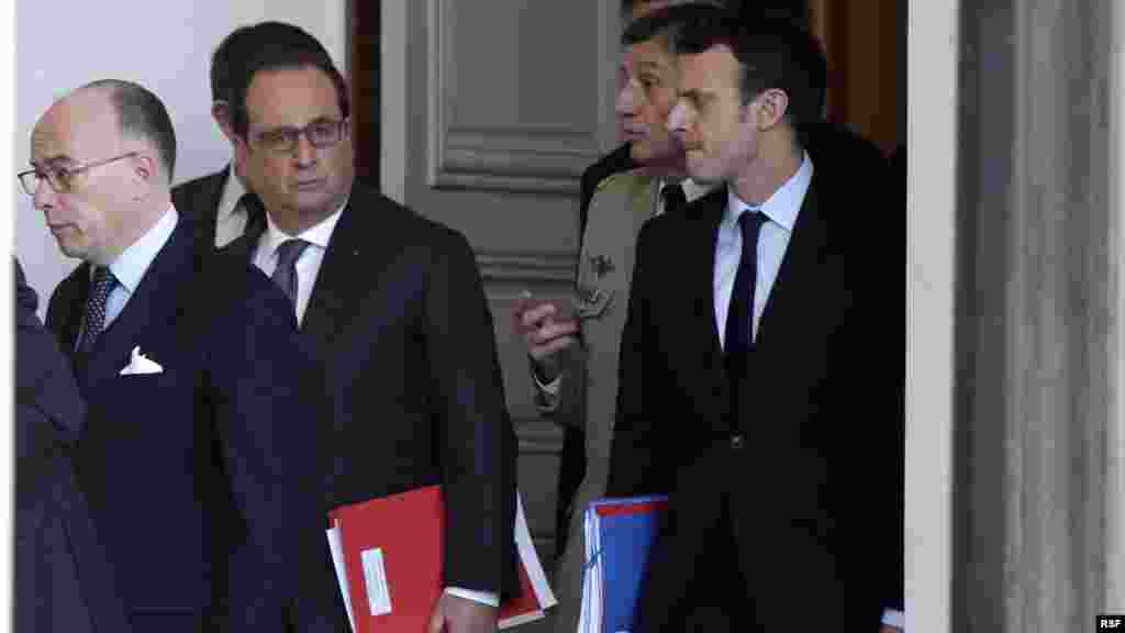 From left, French Interior Minister Bernard Cazeneuve and President Francois Hollande and other officials walk out of the Elysee Palace after a Defense council meeting following attacks Friday in Paris, France, Nov. 14, 2015.