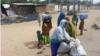 A woman with her children pack what is left of their belongings, following an attack in Kawuri January 28, 2014. An attack by suspected Islamist Boko Haram insurgents on the northeast Nigerian village of Kawuri on Monday killed 85 people, up from 40 previ
