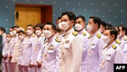 This handout taken and released by Thai Parliament on July 3, 2023 shows Move Forward Party’s leader and prime ministerial candidate Pita Limjaroenrat (C) lining up with fellow MPs before the arrival of Thai King Maha Vajiralongkorn during the official ce