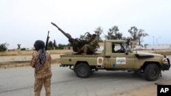 FILE - Tripoli government forces look on during clashes with forces led by Field Marshal Khalifa Haftar south of the capital, Tripoli, Libya, May 21, 2019.