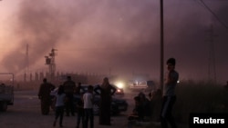People stand together as they flee Ras al Ain town, Syria, Oct. 9, 2019, during an offensive by Turkish troops.