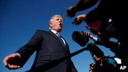 FILE - President Donald Trump speaks with reporters before boarding Air Force One at Morristown Municipal Airport, in Morristown, N.J., Sept. 24, 2017. 