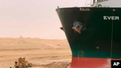 Sur cette photo publiée par l'Autorité du canal de Suez, un cargo, nommé Ever Given, est bloqué avec sa proue enfoncée dans la vase, mercredi 24 mars 2021, au canal de Suez, en Égypte.