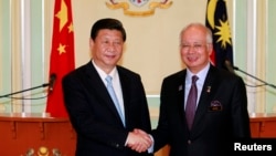 中国国家主席习近平（左）与马来西亚总理纳吉布10月4日在吉隆坡附近举行的记者会上