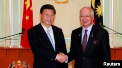 China's President Xi Jinping (L) and Malaysia's Prime Minister Najib Razak shake hands after their joint news conference at Najib's office in Putrajaya, near Kuala Lumpur Oct. 4, 2013.