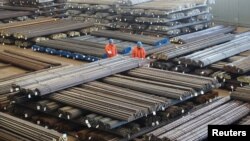 FILE - Workers check steel products at a factory in Dalian, Liaoning Province, China, March 30, 2016. 