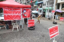A man walks on a blocked street in an area locked down to curb the spread of the coronavirus, in Yangon, Myanmar, Sept. 11, 2020.