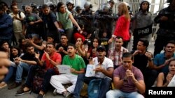Mourners of the municipal lawmaker Fernando Alban shout slogans in front of riot police members standing outside the headquarters of Bolivarian National Intelligence Service (SEBIN) in Caracas, Venezuela, Oct. 8, 2018. 