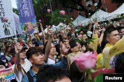 Same-sex marriage supporters hold roses to mourn those who committed suicide because of discrimination during a parliament vote on three draft bills of a same-sex marriage law, outside the Legislative Yuan in Taipei, Taiwan, May 17, 2019.