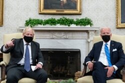 FILE - President Joe Biden, right, listens as British Prime Minister Boris Johnson speaks during a meeting in the Oval Office of the White House, Sept. 21, 2021.